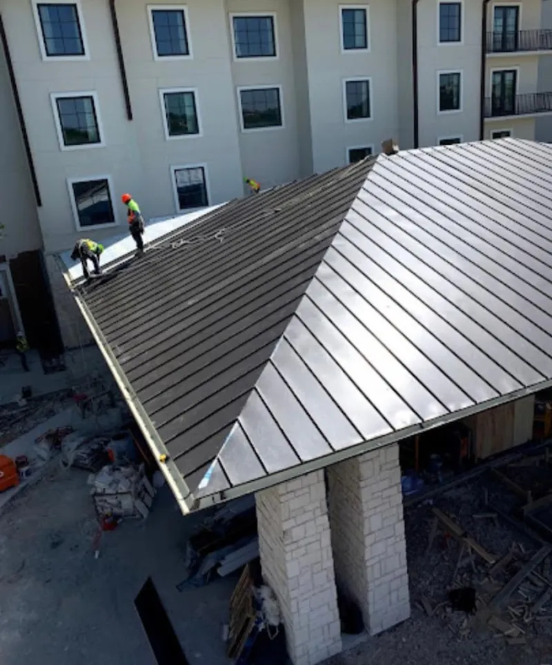 Crew installing standing seam metal roof panels on a commercial project in Rancho Calaveras